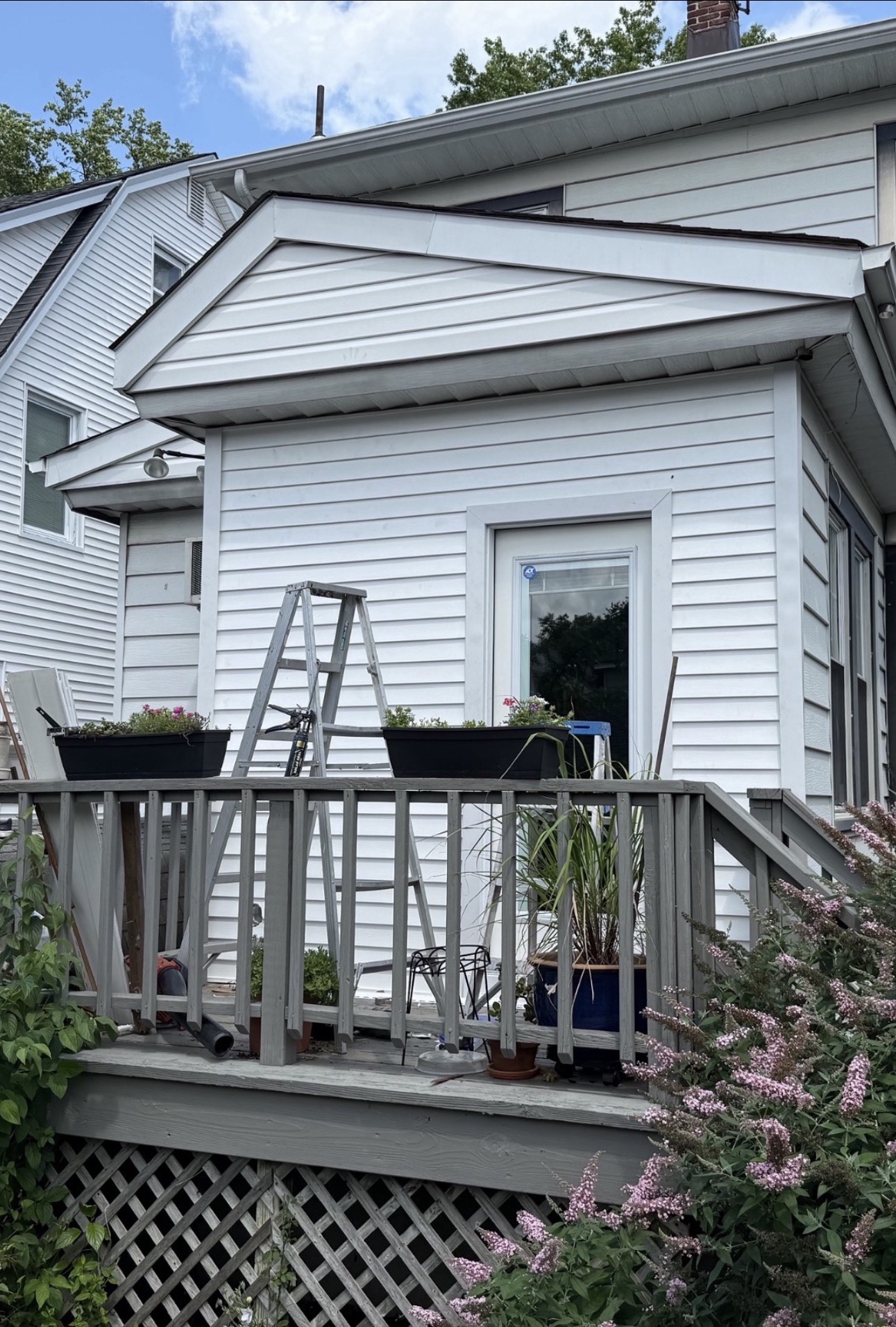 Completed white vinyl siding on a residential addition
