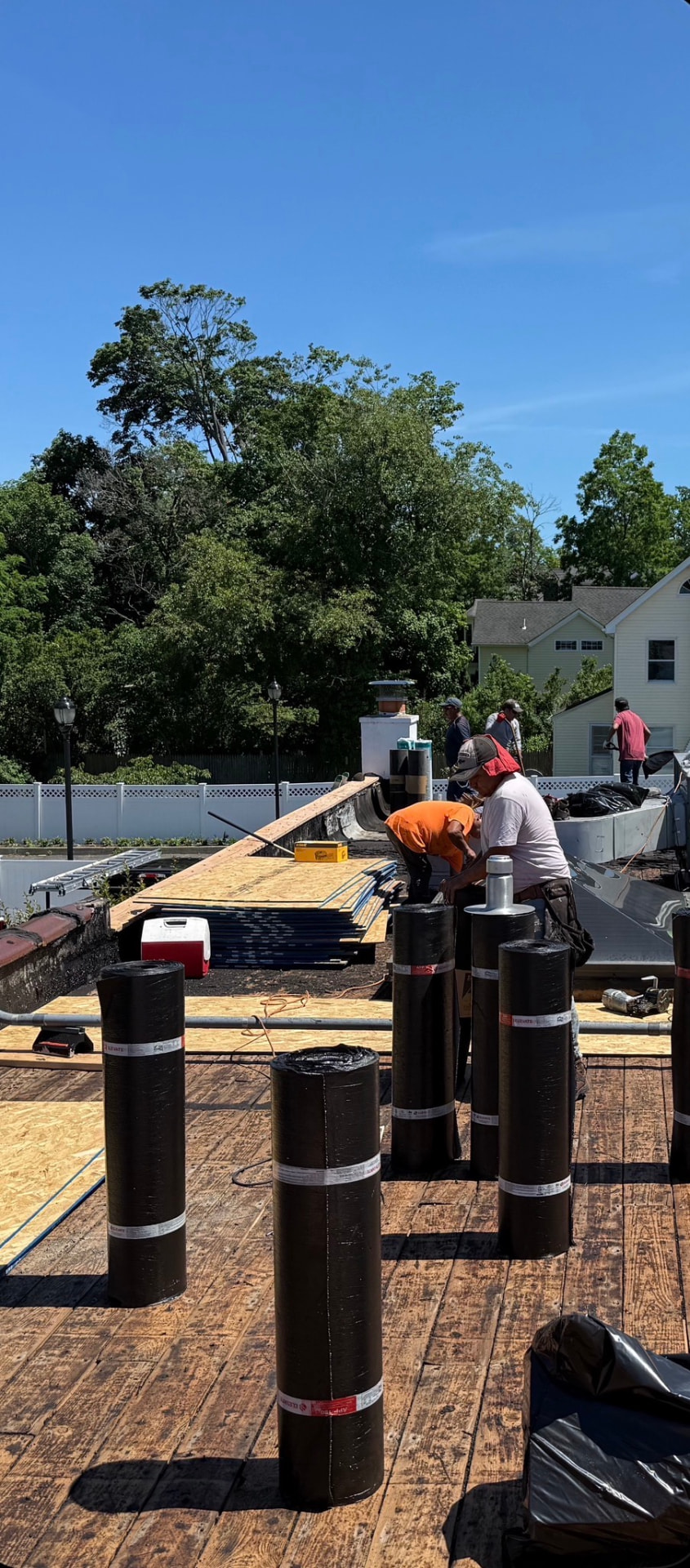 Modified bitumen rolls staged on a commercial roof deck
