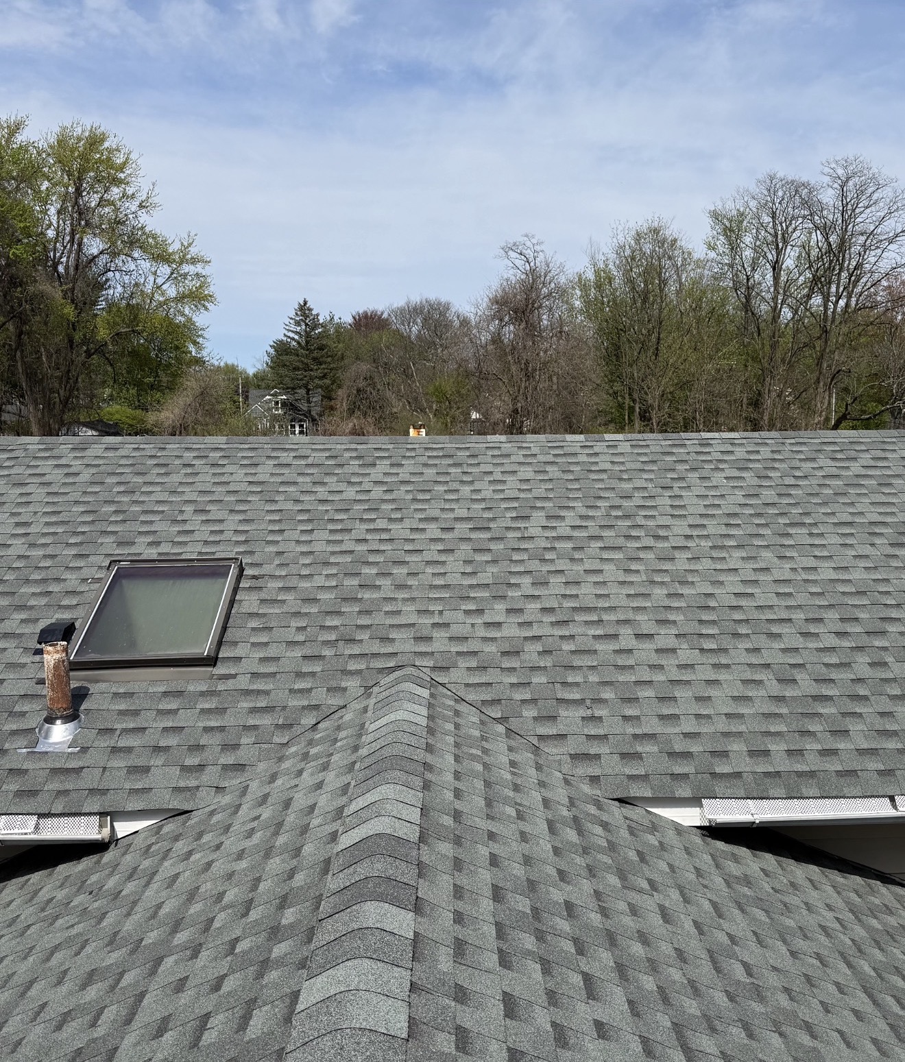 Finished architectural shingle roof with skylight and ridge caps