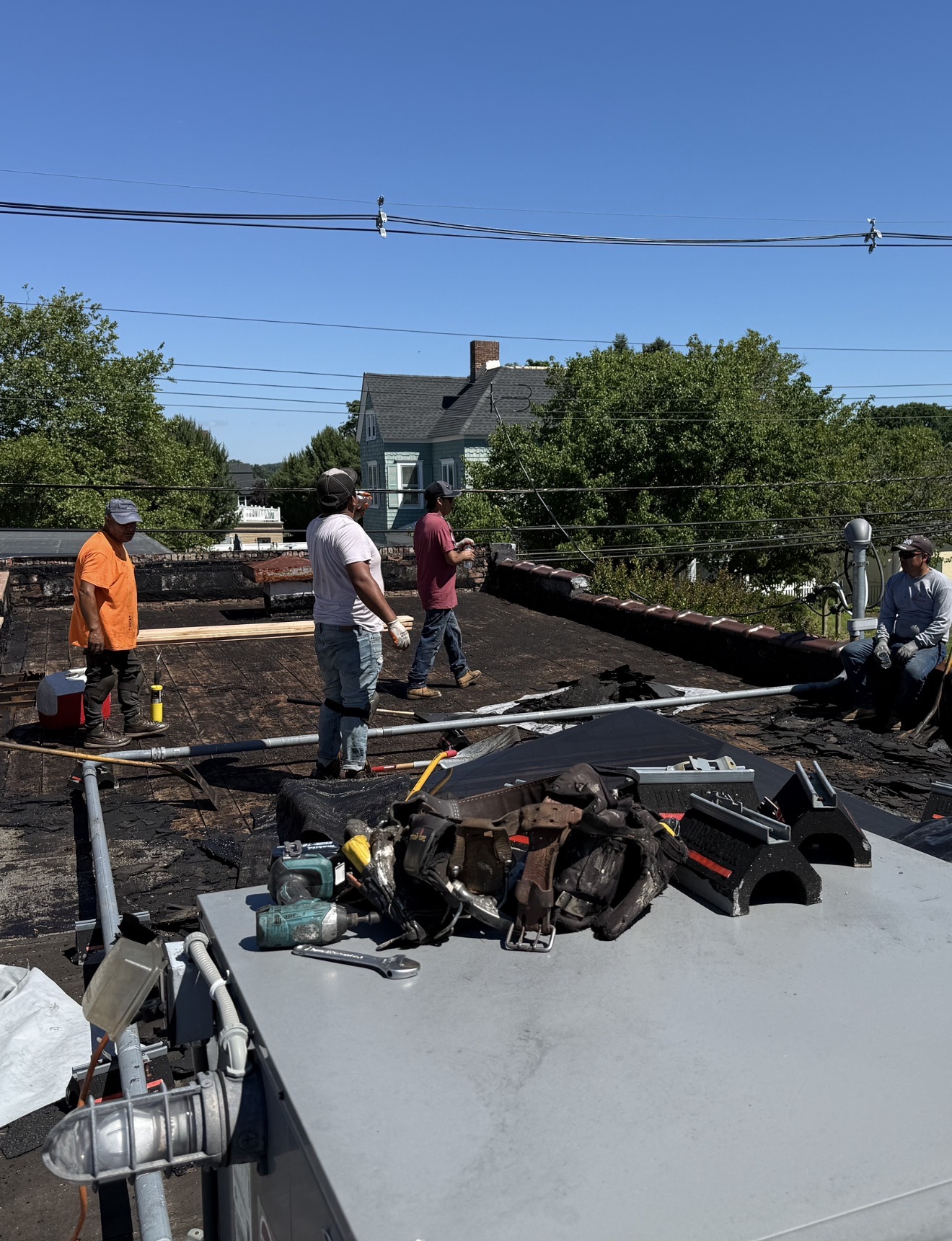 Roofing crew removing an aged commercial roof system