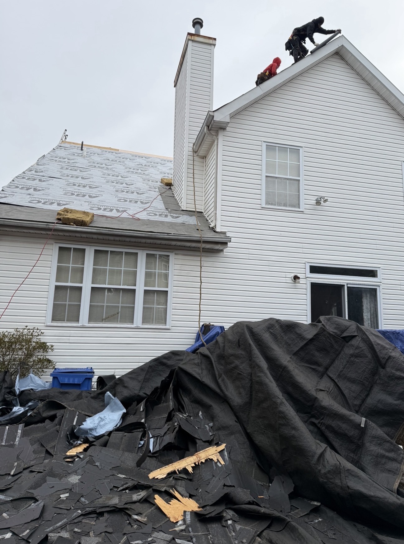 Roofing crew installing underlayment on a residential roof