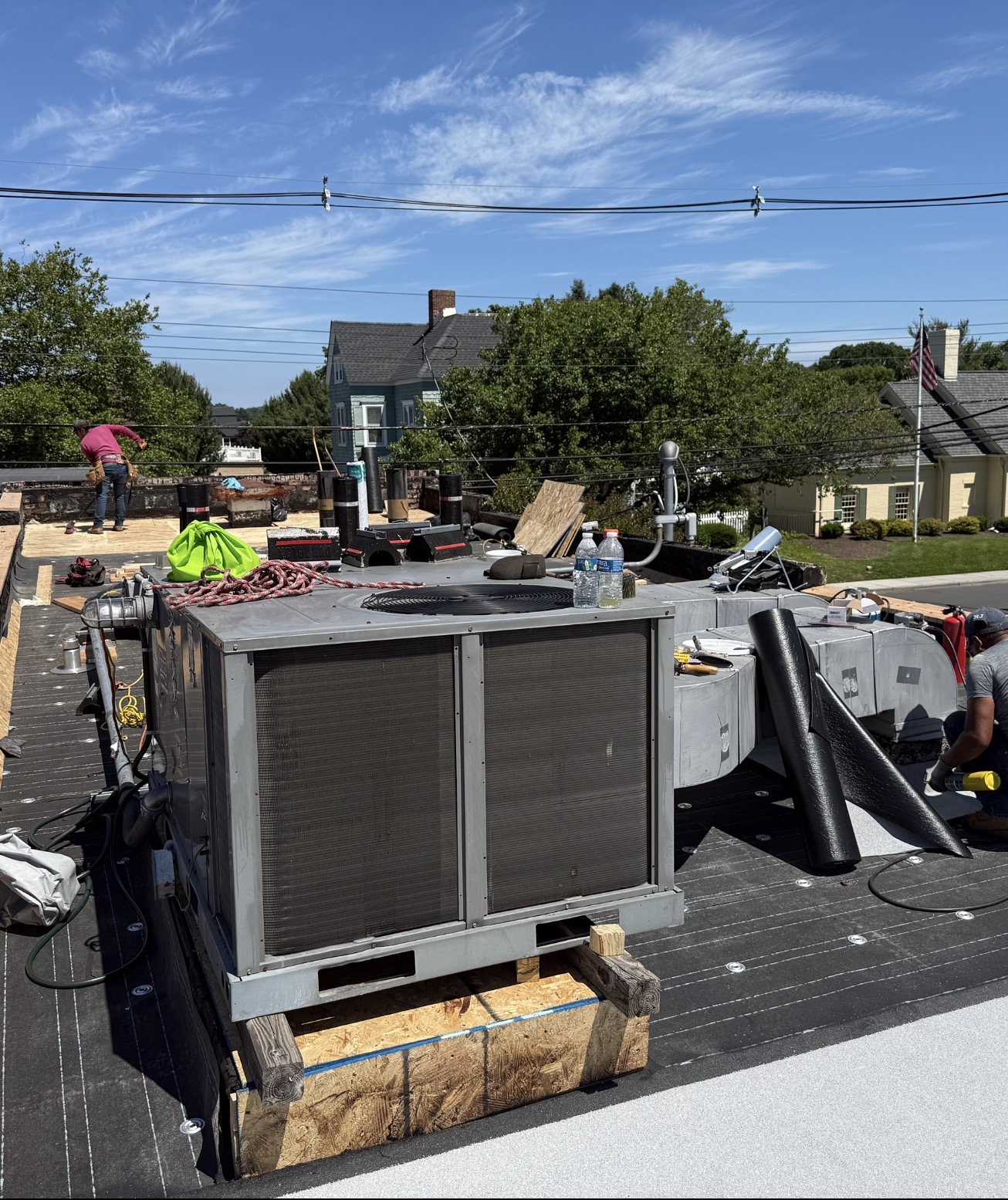Roofing membrane being installed around rooftop HVAC equipment